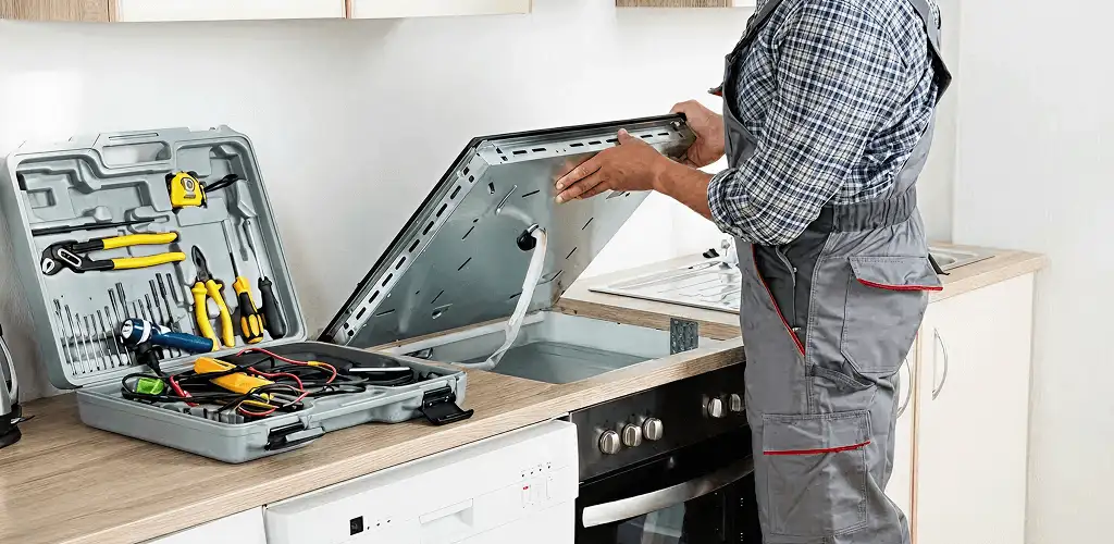 Handyman repairing a cooktop and checking wiring connections in Boise, ID