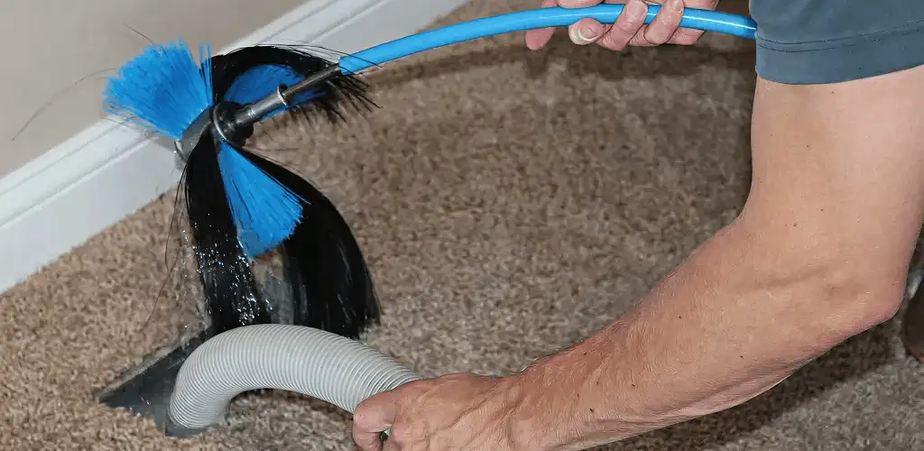 Dryer vent cleaning technician brushing lint from a vent line in Boise, ID