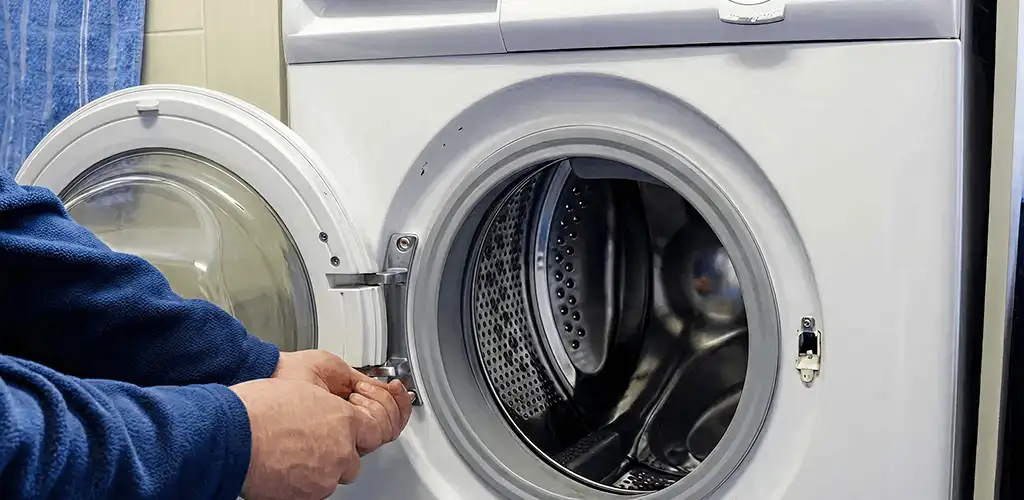 Washing machine repair handyman checking a front-load washer door and latch in Boise, ID
