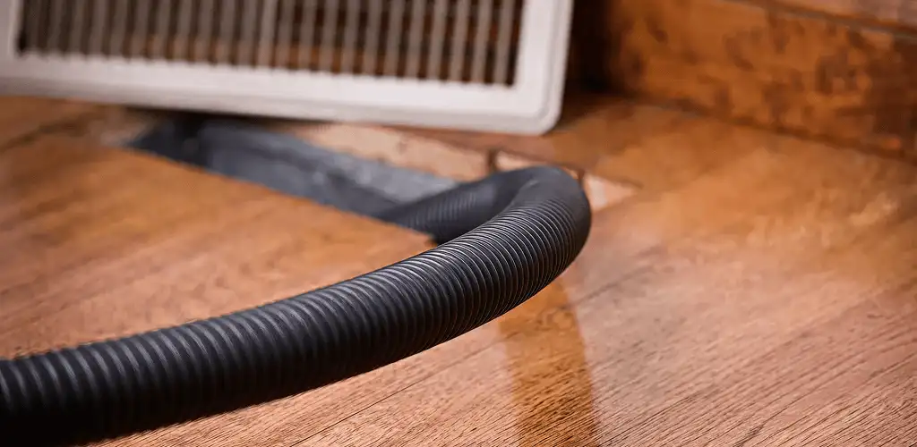 Air duct cleaning hose inserted into a floor vent for ductwork cleaning in Boise, ID