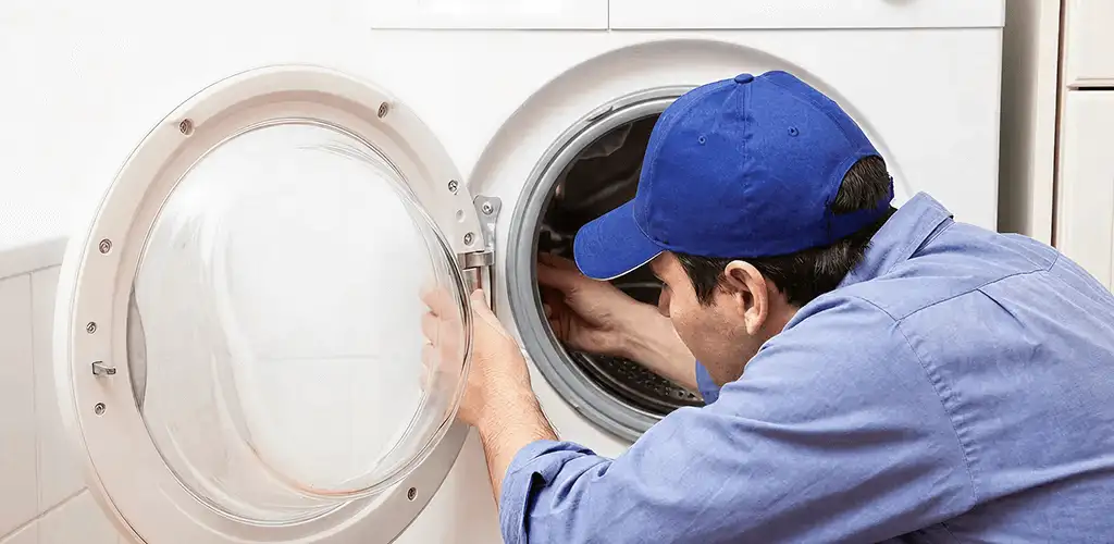 Washing machine repair handyman inspecting a front-load washer drum in Boise, ID