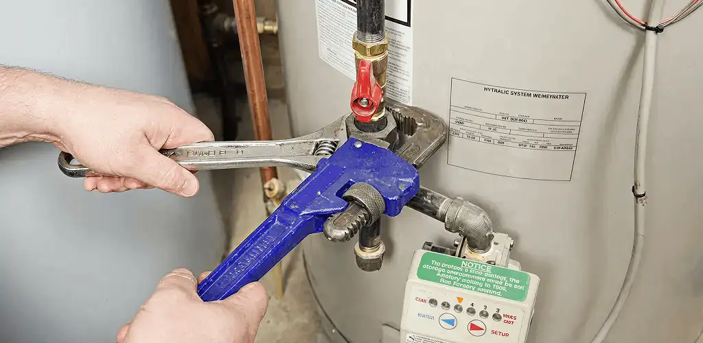Water heater repair technician tightening the shutoff valve and supply line in Boise, ID